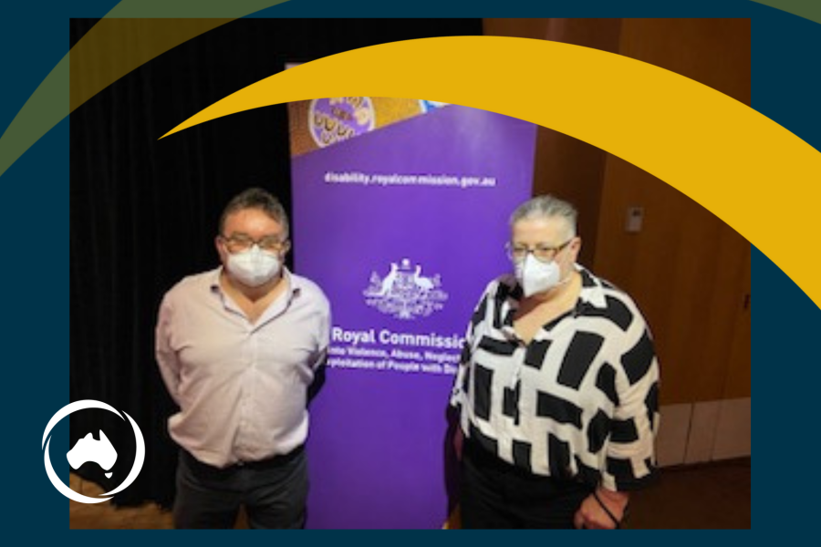 Jeff Smith and El Gibbs wearing face masks in front of a Royal Commission banner.