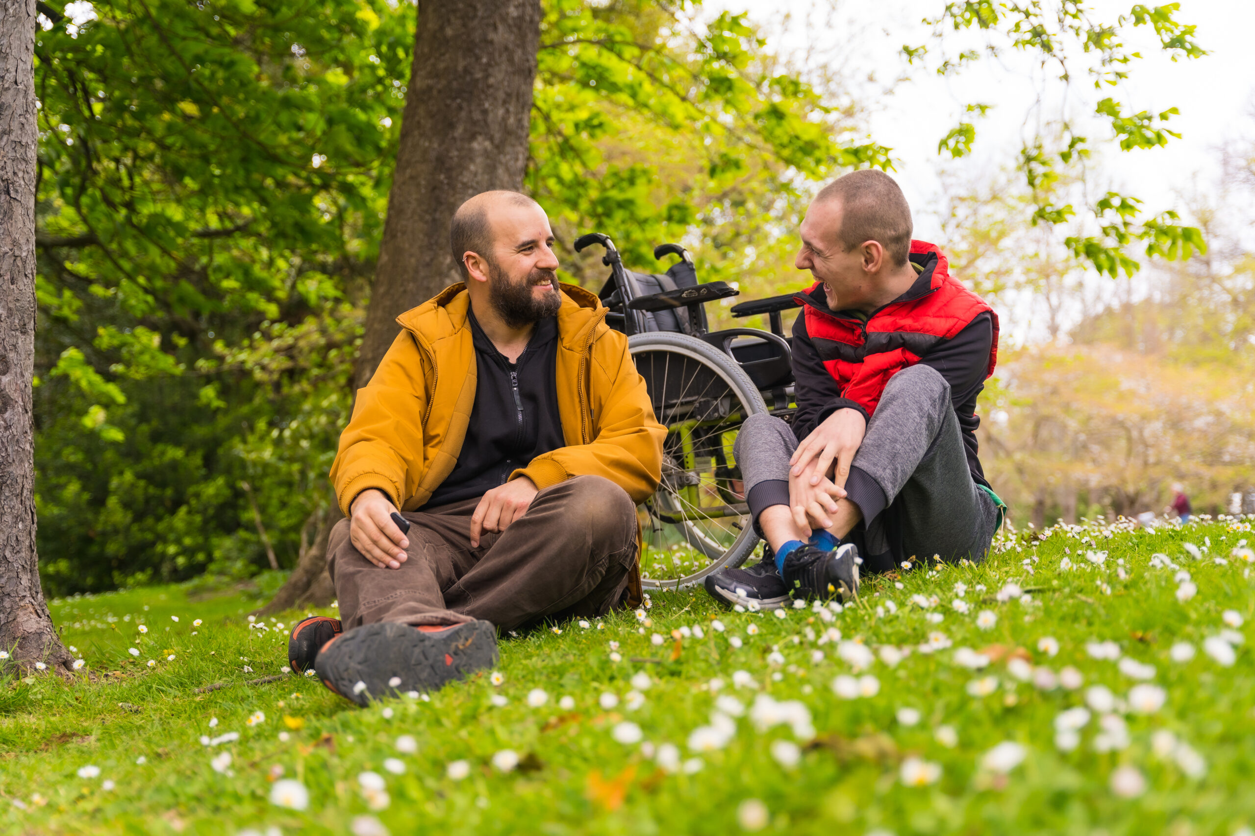 Two disabled men talking in the park stock photo.